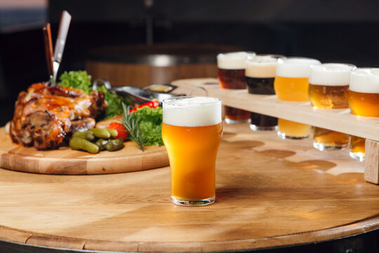 A glass of craft beer at the table, with other beers and snaks at the background