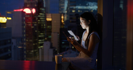 Woman read on tablet and sit beside window