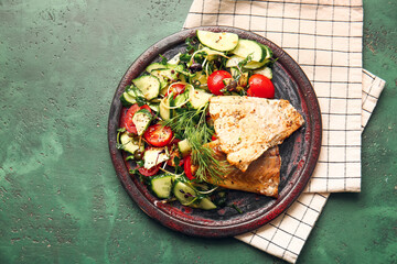 Plate with tasty baked cod fillet and vegetables on color background