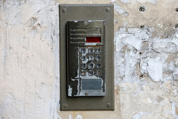 old intercom at the entrance to a residential building