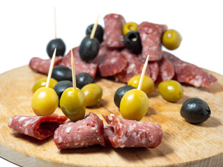 Slicing salami and olives on toothpicks.
