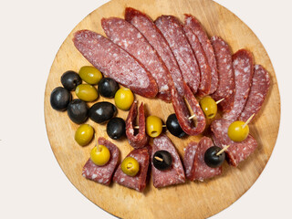 Slicing salami and olives on toothpicks.