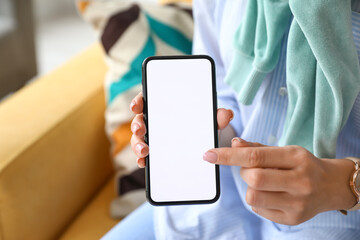 Fashionable woman pointing on blank mobile phone screen, closeup