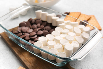 Baking dish with uncooked S'mores dip on light background, closeup