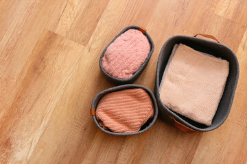 Baskets with clothes on wooden background