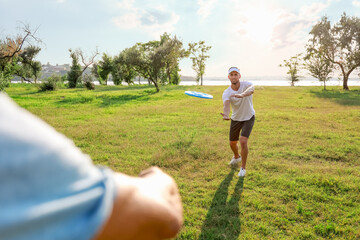 Young men playing frisbee in park