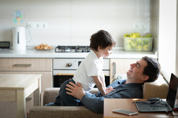 Father and little son having fun together at home in kitchen