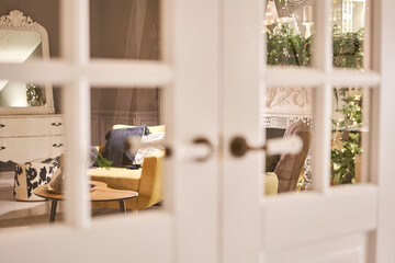 An armchair with pillows in a cozy room Classic apartments with decorated christmas tree and presents. Christmas evening in the light of candles and garlands.