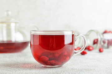 Cup of healthy dogwood berry drink on grey background © Pixel-Shot