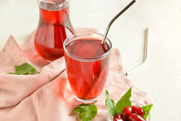 Glass of healthy dogwood berry drink on light background © Pixel-Shot