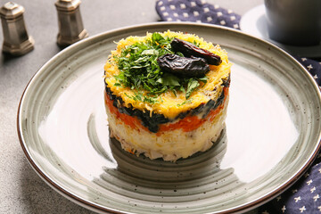Plate with delicious layered salad and prunes, closeup