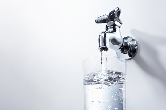 コップに蛇口から出る水を入れる