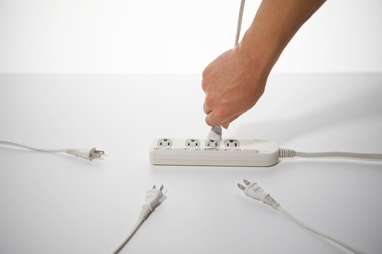 沢山のコンセントとプラグと手