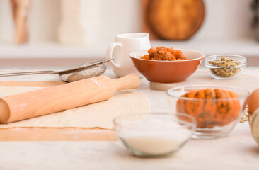 Raw dough and ingredients for preparing pumpkin strudel on table, closeup