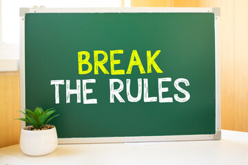 Break the Rules in chalk on the school board, Search engine optimization and websites. Desk, swept balls of paper, computer keyboard