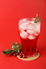 Glass with tasty cranberry juice on color background