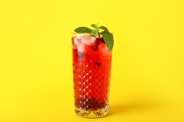 Glass with tasty cranberry juice on color background