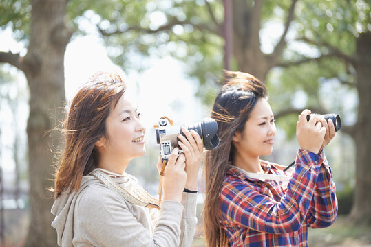 一眼レフカメラで撮影する二人の女性