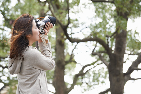 一眼レフカメラで撮影する女性