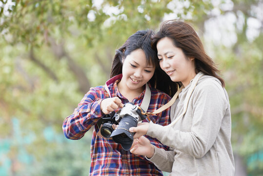 一眼レフカメラで撮影する二人の女性
