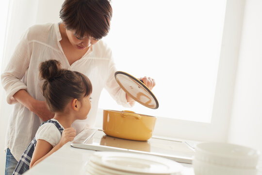 キチンでママの料理を手伝う女の子