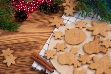 full plate of homemade freshly made gingerbread cookies on wooden background. Christmas tree decorations on the table. Classic traditional Christmas cookies with spices, cinnamon, cumin and ginger