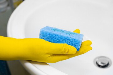 The process of cleaning the washbasin in the bathroom.