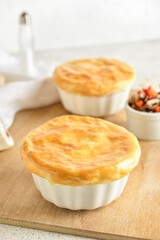 Wooden board tasty vegetable pot pies on white background