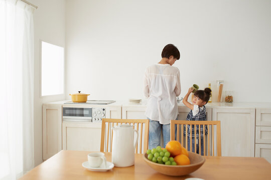 キチンでママの料理を手伝う女の子