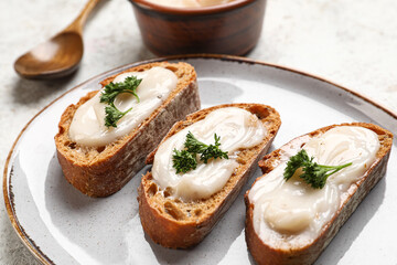 Plate of bread with lard spread on light background