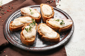 Plate of bread with lard spread on light background