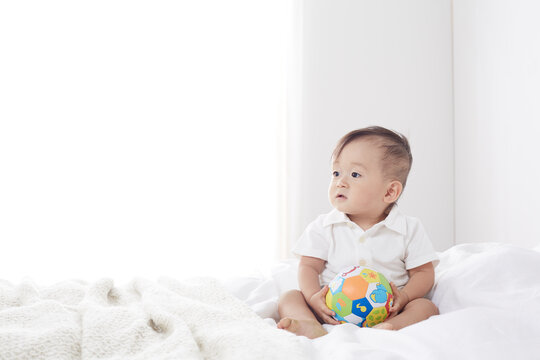 ベッドの上で遊ぶ赤ちゃん