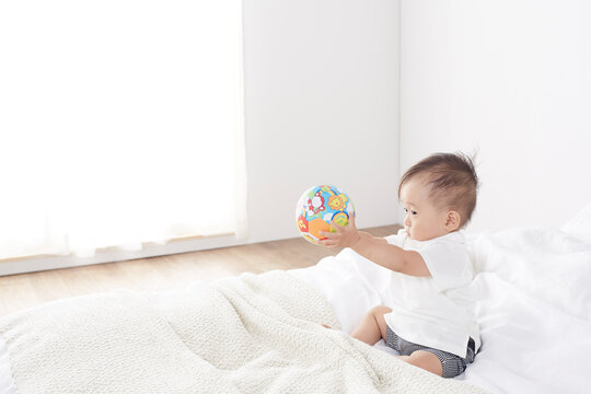 ベッドの上で遊ぶ赤ちゃん