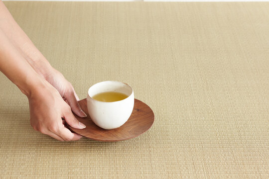 お茶を差し出す女性の手