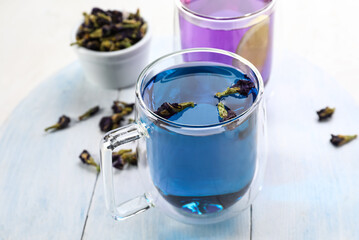 Cup of butterfly pea flower tea on table
