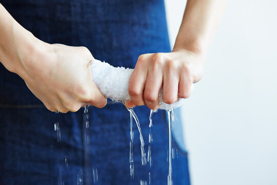 白い雑巾を絞る女性の手