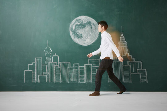 ビル群と満月が描かれた黒板イラストを横切る