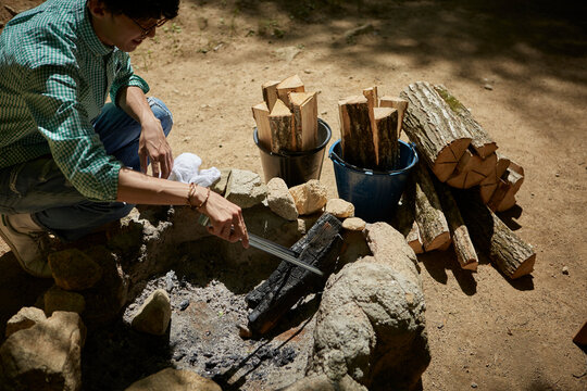 薪をつつく一人の男性