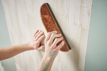 壁紙を貼る男性の手