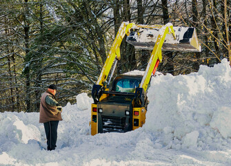 After a winter snow storm the snow plow gets stuck clearing the road.