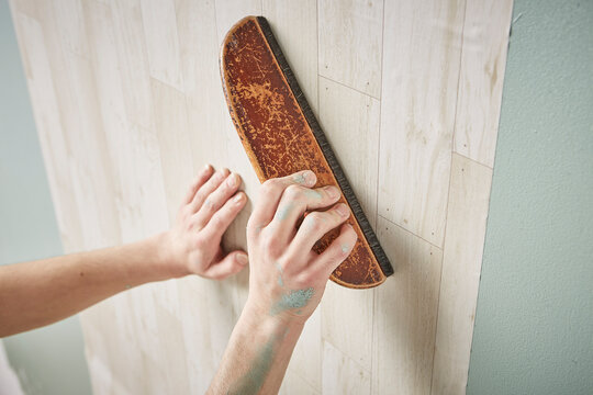 壁紙を貼る男性の手