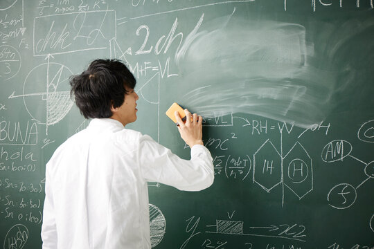 数式の書かれた黒板を消す