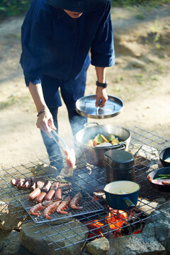 キャンプ場で食材を調理する女性