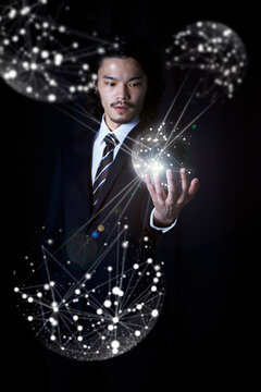 光の粒から出た線が手のひらに集まったビジネスマン