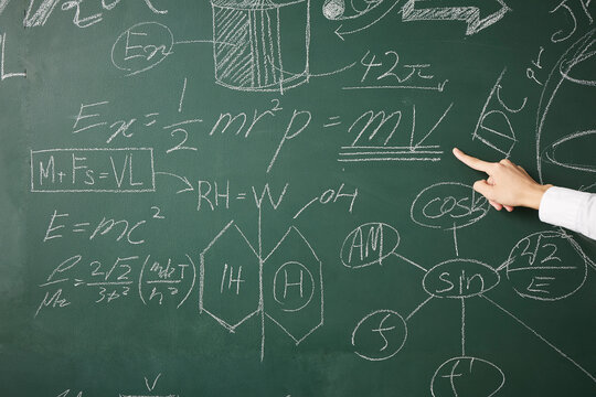 黒板に書かれた数式に指を指す