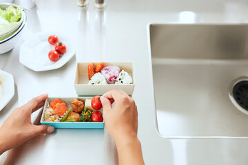 キッチンでお弁当を作る女性の手元