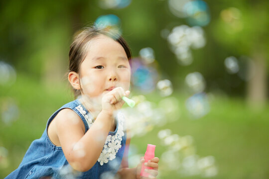 公園でシャボン玉で遊ぶ少女