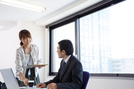 上司にお茶を配る女性