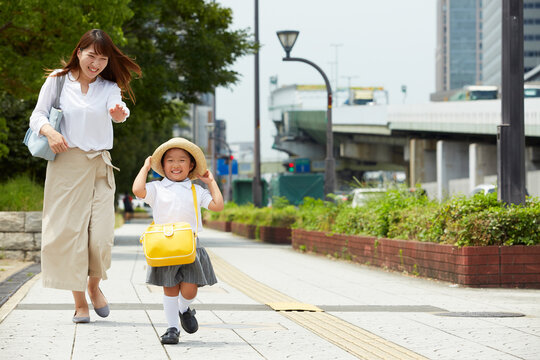 歩行者道路を走る子供と追いかける母親