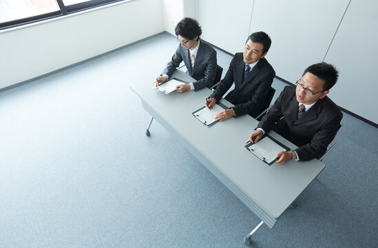 オフィスで面接をしている３人の男性